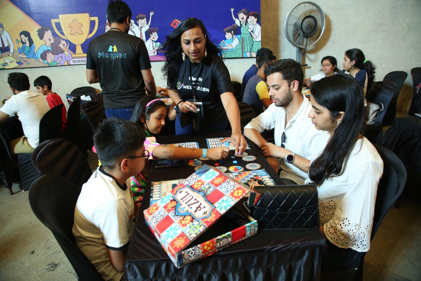 Volunteer helping families at Meeplecon